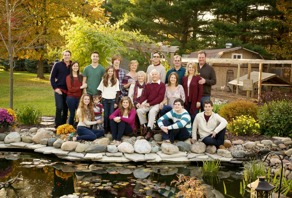 Extended family portrait session with generations in front of a pond