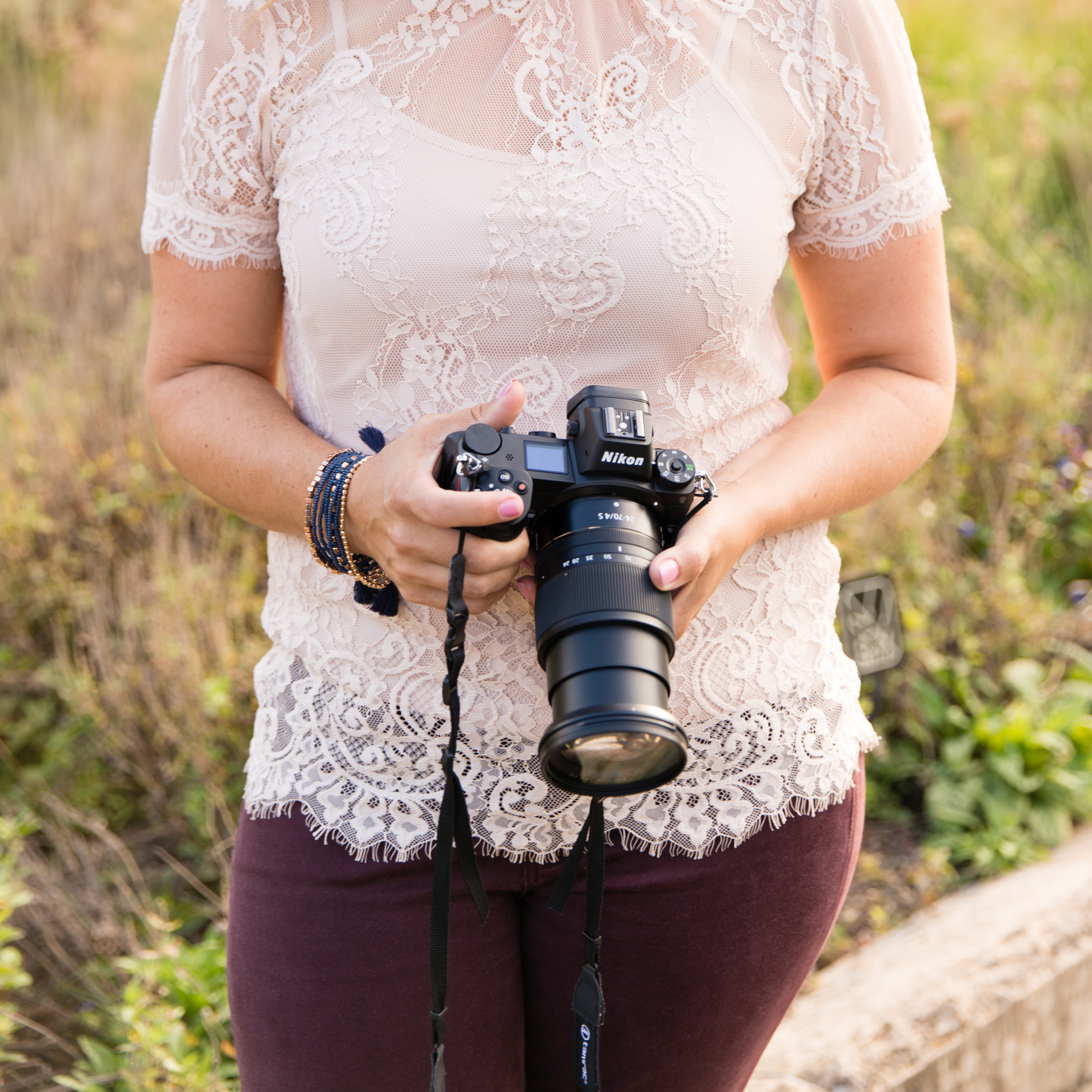 Woman Photographer Holding a Nikon Camera with a Lace Top