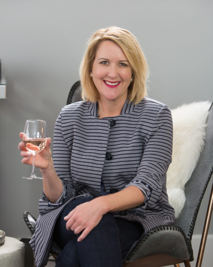 Woman entrepreneur enjoying wine while smiling at the camera in her Michigan Branding photo session.