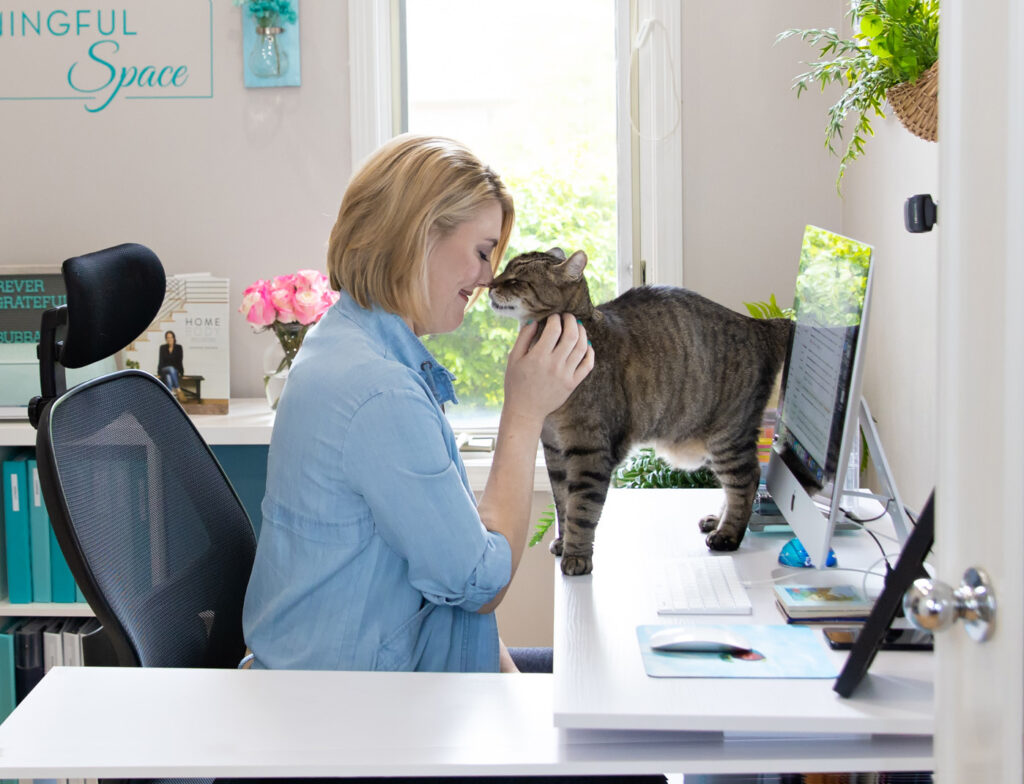 A business owner and her cat enjoying a tender moment in her office.
