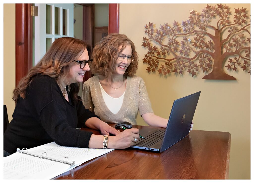 Two female business partners looking at a laptop together.