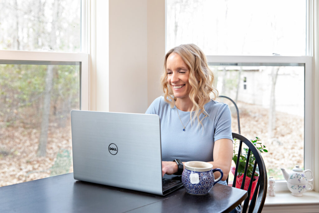 Entrepreneur working on her laptop, updating her professional online presence.